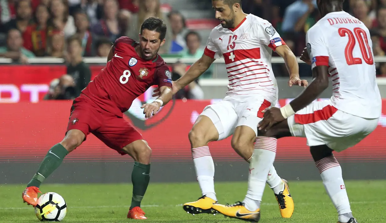 Gelandang Portugal, Joao Moutinho, berusahan melewati bek Swiss, Ricardo Rodriguez, pada laga kualifikasi Piala Dunia di Stadion Luz, Selasa (10/10/2017). Portugal menang 2-0 atas Swiss. (AP/Armando Franca)