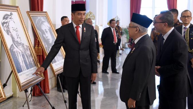 Presiden Joko Widodo (kiri) menunjukkan foto Sultan Himayatuddin Muhammad Saidi kepada Wakil Presiden Ma'ruf Amin di Istana Negara, Jakarta, Jumat (8/11/2019). Himayatuddin mendapat gelar Pahlawan Nasional berdasarkan Keppres Nomor 120/TK/Tahun 2019. (Foto: Lukas-Biro Pers Sekretariat Presiden)