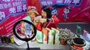 Para petani yang mengenakan kostum etnis Qiang menjual produk lokal melalui siaran langsung daring (livestream) di Beichuan, Provinsi Sichuan, China, 14 November 2020. Acara livestream yang menghadirkan berbagai produk pengentasan kemiskinan dibuka di Beichuan, Sabtu (14/11). (Xinhua/Jiang Hongjing)