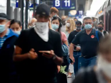 Penumpang berjalan di sepanjang peron di stasiun kereta utama di Frankfurt, Jerman, Jumat (14/8/2020). Mengenakan masker untuk melindungi diri dari corona Covid-19 adalah kewajiban di transportasi umum di Jerman. (AP Photo/Michael Probst)