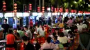 Warga menikmati makanan ringan di sebuah pasar malam di Haikou, ibu kota Provinsi Hainan, China selatan (26/3/2020). Kehidupan masyarakat di provinsi tersebut secara bertahap mulai kembali normal. (Xinhua/Guo Cheng)