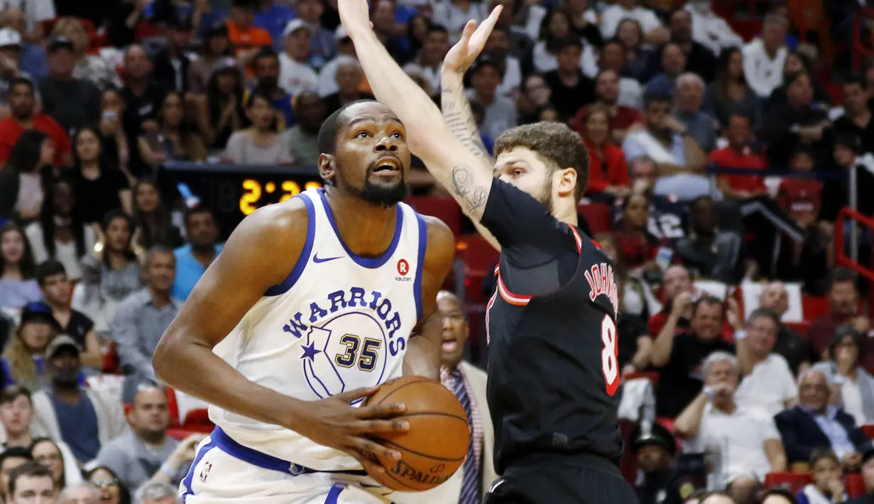 Pebasket Golden State Warriors, Kevin Durant, berusaha melewati pebasket Miami Heat, Tyler Johnson, pada laga NBA di American Airlines Arena, Miami, Senin (4/12/2017). Warriors menang 123-95 atas Heat. (AP/Joe Skipper)