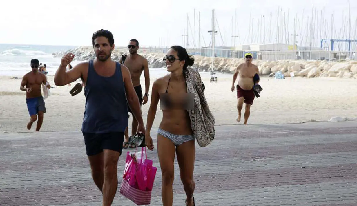 Militer Israel mengingatkan pengunjung pantai untuk berlindung karena militan Palestina diduga akan melancarkan roket balasan ke sekitar pantai, Israel, Senin (14/07/2014) (AFP PHOTO/GALI TIBBON)