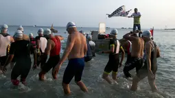 Peserta menuju bibir pantai sebelum berenang ketika Rhino Cross Triathlon 2018 di Kawasan Tanjung Lesung, Pandeglang, Banten, Minggu (30/9). Rhino Cross Triathlon digelar untuk meningkatkan potensi wisata Tanjung Lesung. (Liputan6.com/HO/Nick Hanoatubun)