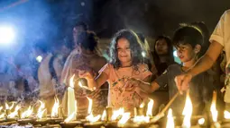 Anak-anak menyalakan lilin dalam kegiatan Earth Hour Internasional di Myanmar (25/3). Tahun ini gerakan Earth Hour melibatkan pemadaman listrik selama satu jam di 7.000 kota di 172 negara. (AFP/Ye Aung Thu)