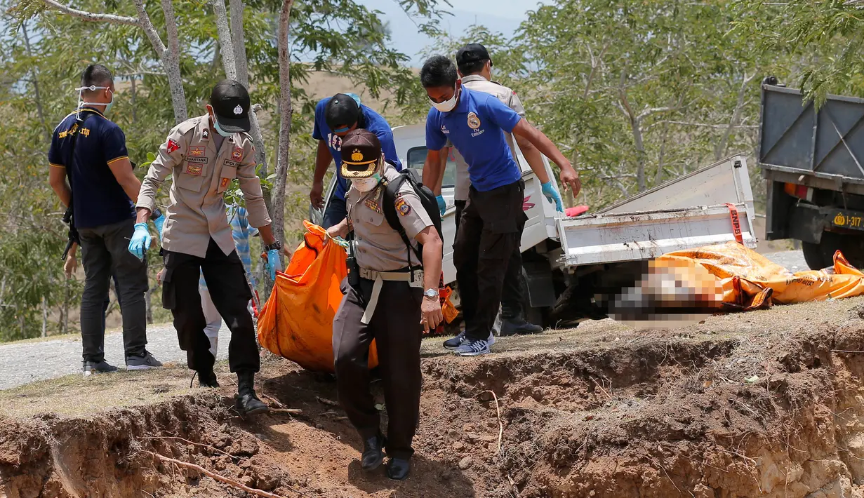 Petugas membawa jenazah korban gempa dan tsunami untuk dimakamkan massal di Palu, Sulawesi Tengah, Senin (1/10). (AP Photo/Tatan Syuflana)