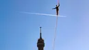 Seniman trapeze, Nathan Paulin berjalan di seutas tali ketika melakukan slackline dari Menara Eiffel menuju alun-alun Trocadero di Paris, 9 Desember 2017. Aksi menegangkan itu dilakukan dengan ketinggian sekitar 200 kaki. (JACQUES DEMARTHON/AFP)
