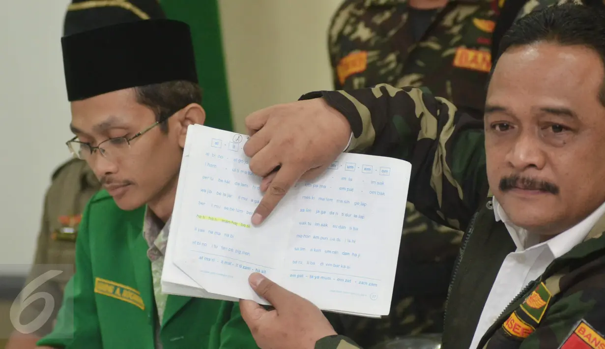 Wakil Ketum GP Ansor Benny Rhamdani menunjukkan tulisan yang berbunyi "ha ti ha ti man haj ba til" dari buku pelajaran tingkat TK yang isinya memuat unsur radikalisme saat jumpa pers di Kantor GP Ansor, Jakarta, Rabu (20/1). (Liputan6.com/Faizal Fanani)