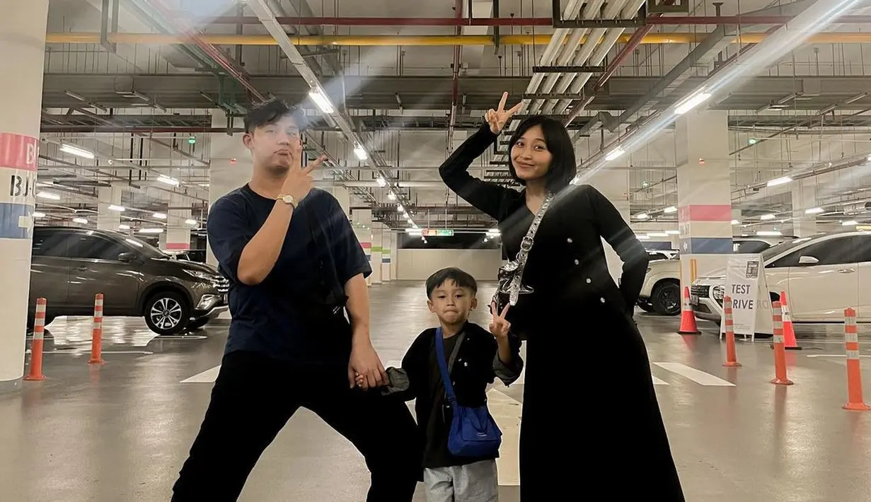 Inspirasi dress hitam lainnya dari Rini Wulandari yang dipadukan dengan cardigan warna senada dan sepatu kets warna putih yang stylish. [IG Rinni Wulandari]