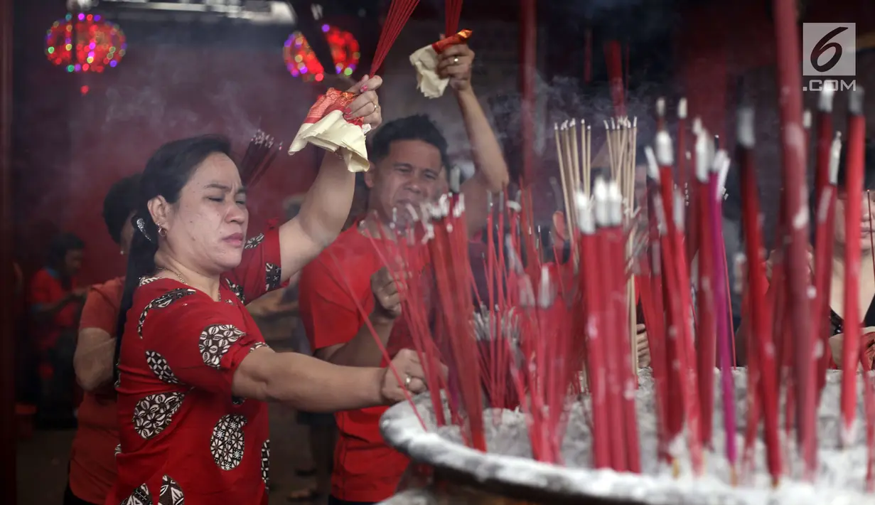 Warga keturunan Tionghoa meletakkan dupa usai persembahyangan Imlek 2569 di Vihara Dharma Bhakti, Petak Sembilan, Jakarta, Jumat (16/2). Selain membakar dupa dan memanjatkan doa, mereka juga saling bercengkrama satu sama lain. (Liputan6.com/Arya Manggala)