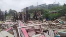 Personel Polres Bogor berdiri di atas sisa reruntuhan bangunan yang dibongkar di Kampung Naringgul, Kabupaten Bogor, Kamis (29/8/2019). Puluhan bangunan rumah yang sebagian merupakan penginapan dan rumah kos-kosan tersebut dibongkar Satpol PP lantaran tidak memiliki izin. (Liputan6.com/Alby Azka)