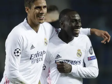 Bek Real Madrid, Ferland Mendy (kanan) bersama Raphael Varane merayakan kemenangan 1-0 atas Atalanta usai berakhirnya laga leg pertama babak 16 Besar Liga Champions 2020/21 di Gewiss Stadium, Bergamo, Rabu (24/2/2021). (AP/Luca Bruno)