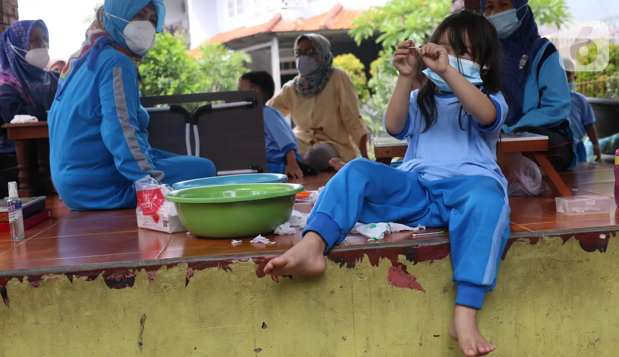 Sejumlah murid Pendidikan Anak Usia Dini (PAUD) Anyelir Karang Tengah mengikuti kegiatan belajar di luar ruangan di kota Tangerang, Kamis (18/11/2021). Mereka terpaksa belajar di teras lantaran gedung untuk PAUD Anyelir dikunci oleh Ketua RW dan diharuskan membayar. (Liputan6.com/Angga Yuniar)