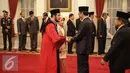 Presiden Joko Widodo memberi selamat  usai Wakil Ketua Mahkamah Konstitusi Anwar Usman mengucapan sumpah sebagai Hakim Konstitusi di Istana Negara, Jakarta, Kamis (6/4). (Liputan6.com/Faizal Fanani)