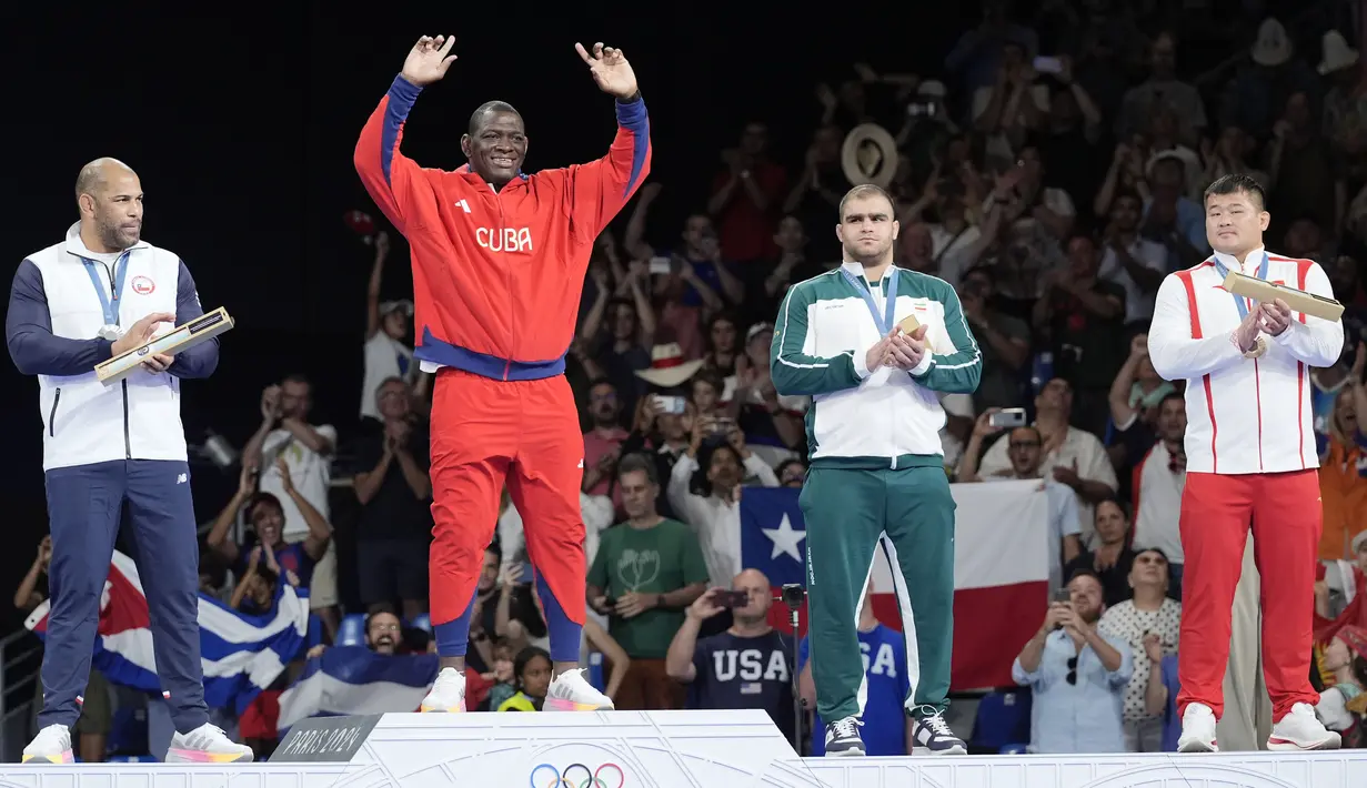 Pegulat Kuba, Mijain Lopez, meraih medali emas Olimpiade Paris 2024 lewat nomor gulat Greco-Roman 130 kg. Emas Olimpiade kali ini merupakan yang kelima didapatnya secara beruntun. Setelah pencapaian luar biasa tersebut Lopez memutuskan menutup kariernya. (AP Photo/Eugene Hoshiko)