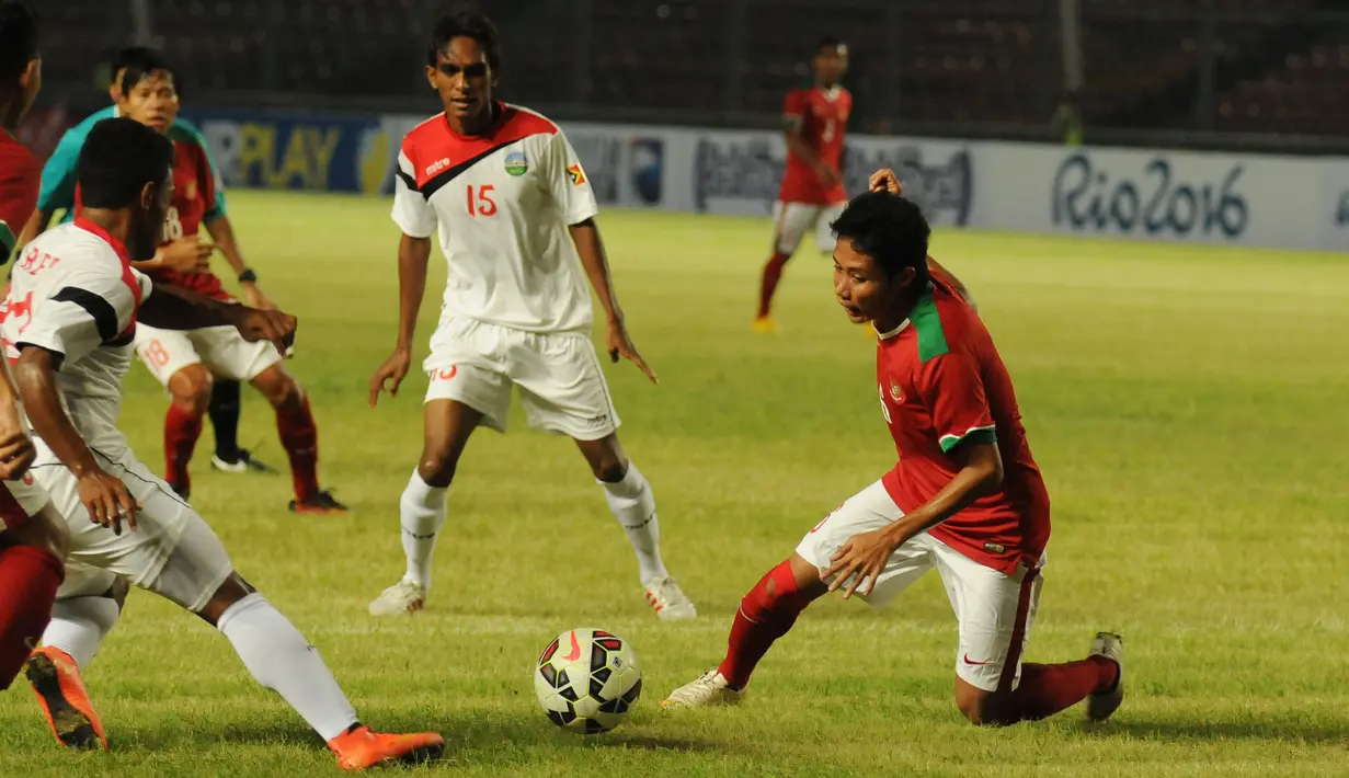 Gelandang timnas Indonesia U-23, Evan Dimas (kanan) berebut bola dengan pemain Timor Leste di laga kualifikasi grup H Piala Asia 2016 di Stadion GBK Jakarta, (27/3/2015). Indonesia U-23 unggul 5-0 atas Timor Leste. (Liputan6.com/Helmi Fithriansyah)
