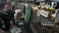Warga menggantungkan sayuran, beras, dan bumbu masak untuk digantungkan pada pagar rumah di Gang Palautan, Cilodong, Depok, Jumat (21/1/2022). Warga Rt 04 Rw 01 di kawasan tersebut secara swadaya berbagi setiap hari Jumat kepada warga lainnya yang terdampak pandemi. (Liputan6.com/Herman Zakharia)