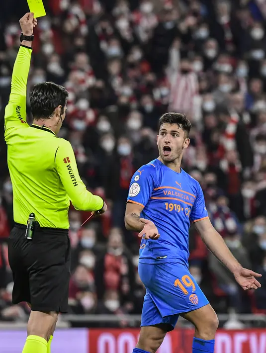 Penyerang Valencia, Hugo Duro mendapat kartu kuning dari wasit saat bertanding melawan Athletic Bilbao pada pertandingan leg pertama semifinal Copa del Rey di stadion San Mames di Bilbao, Spanyol, Jumat (11/2/2022). Athletic Bilbao bermain imbang atas Valencia 1-1. (AP Photo/Alvaro Barrientos)