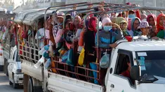 Para pekerja menaiki mobil bak terbuka sebagai transportasi harian mereka pulang ke rumah dari tempat kerja di sebuah pabrik di dekat desa Trapang Anchanh, di luar Phnom Penh, Kamboja (27/10). (AP Photo/Heng Sinith)