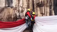 Tim langit sedang mengibarkan bendera merah putih raksasa di tebing Mandala 125 pabeasan.