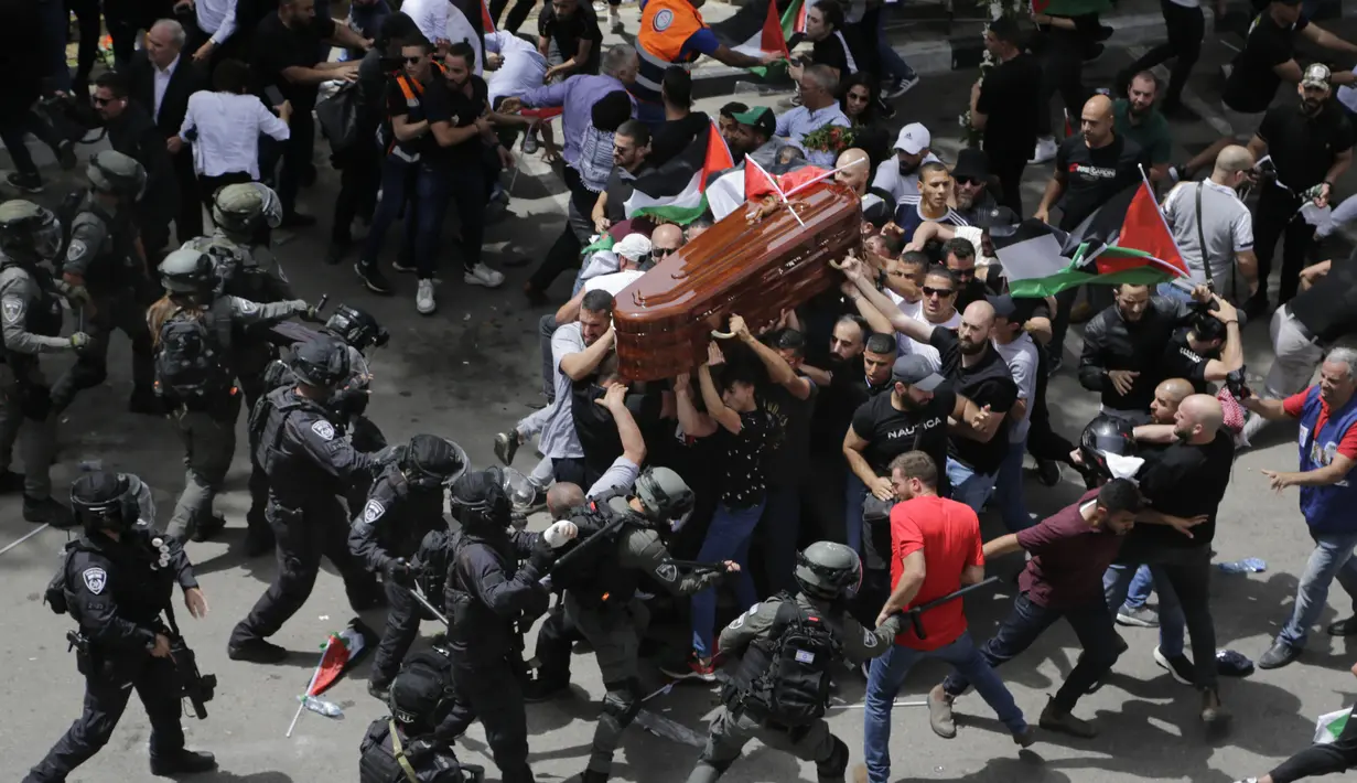 <p>Polisi Israel berhadapan dengan pelayat saat mereka membawa peti mati jurnalis veteran Al Jazeera yang terbunuh Shireen Abu Akleh selama pemakamannya di Yerusalem timur, 13 Mei 2022. Shireen Abu Akleh , seorang reporter Palestina-Amerika yang meliput konflik Timur Tengah selama lebih dari 25 tahun, terkena tembakan di kepala pada hari 11 Mei 2022 lalu dalam serangan militer Israel di kota Jenin di Tepi Barat. (AP Photo/Maya Levin)</p>