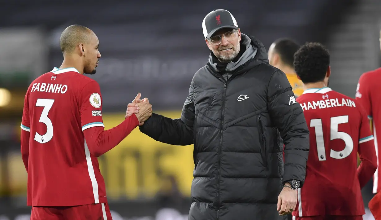 Manajer tim Liverpool, Jurgen Klopp bersama gelandang Fabinho merayakan kemenangan 1-0 atas Wolverhampton Wanderers usai berakhirnya laga lanjutan Liga Inggris 2020/2021 pekan ke-28 di Molineux Stadium, Senin (15/3/2021). (AP/Paul Ellis/Pool)