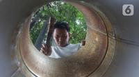 Seorang pengrajin membuat penanak nasi  di Pamulang, Tangerang Selatan, Banten  Minggu( 12/1/2020). Perabot tersebut dibuat dari bahan aluminium seperti dandang, oven, panci dan ventilator dijual dengan harga 100 sampai 300 ribu rupiah tergantung besar kecilnya. (merdeka.com/Arie Basuki)