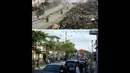 File foto (atas) diambil pada 9 Januari 2005 jalan dibersihkan dari tumpukan puing-puing di kedua sisi, di Meulaboh, Aceh. Foto di lokasi yang sama diambil pada 29 November 2014. (AFP PHOTO/PHILIPPE DESMAZES-atas, AFP PHOTO/Bay Ismoyo-bawah)