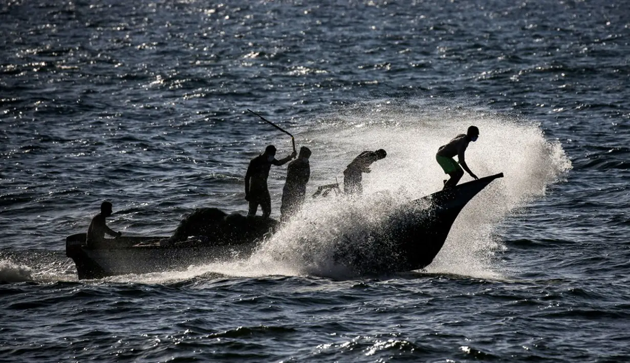 Nelayan Palestina naik perahu menerjang ombak saat menangkap ikan di Laut Mediterania, Rafah, Jalur Gaza, Rabu (2/9/2020). (SAID KHATIB/AFP)