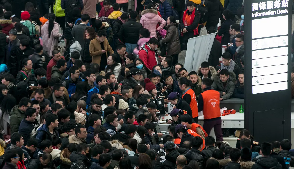 Penumpang berkerumun untuk mendapatkan pengembalian tiket kereta setelah perjalanan mereka tertunda akibat salju tebal yang menyelimuti provinsi Zhejiang, Senin (1/2). Warga China sedang mempersiapkan untuk menyambut Tahun Baru Imlek. (REUTERS/Stringer)