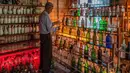 Tengku Mohamad Ali Mansor memeriksa botol kaca di museum botolnya di desa Penarik di Malaysia pada 12 September 2020.  Upaya seorang lansia Malaysia untuk membersihkan pantai-pantai negara itu dari kaca-kaca yang terkelupas membuatnya mengumpulkan koleksi ribuan botol. (AFP/Mohd Rasfan)