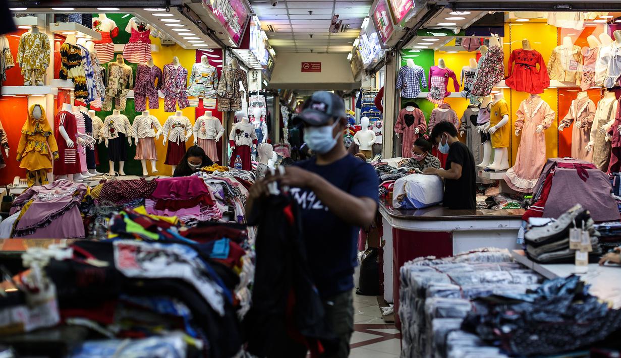 Pedagang pakaian menata dagangannya di Pasar Tanah Abang, Jakarta, Selasa (27/7/2021). Pasar Tanah Abang yang kembali dibuka mulai Senin (26/7) mewajibkan pengunjung serta pedagang menunjukkan sertifikat vaksinasi COVID-19 untuk masuk ke pasar. (Liputan6.com/Johan Tallo)
