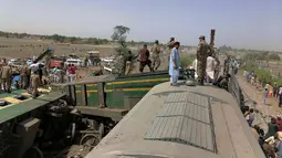 Pasukan dan penyelamat bekerja di lokasi tabrakan kereta api di distrik Ghotki di Pakistan selatan, Senin (7/6/2021). Sedikitnya 30 orang tewas serta puluhan penumpang luka-luka akibat kecelakaan tersebut dan telah dievakuasi ke rumah sakit. (Inter Services Public Relations vis AP)