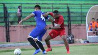 Gelandang PSIM Yogyakarta, Achmad Hisyam Tolle (biru), berduel dengan pemain Persipura Jayapura, Titus Bonai dalam uji coba di Stadion Gemilang, Kabupaten Magelang, Rabu (1/5/2019). (Vincentius Atmaja)