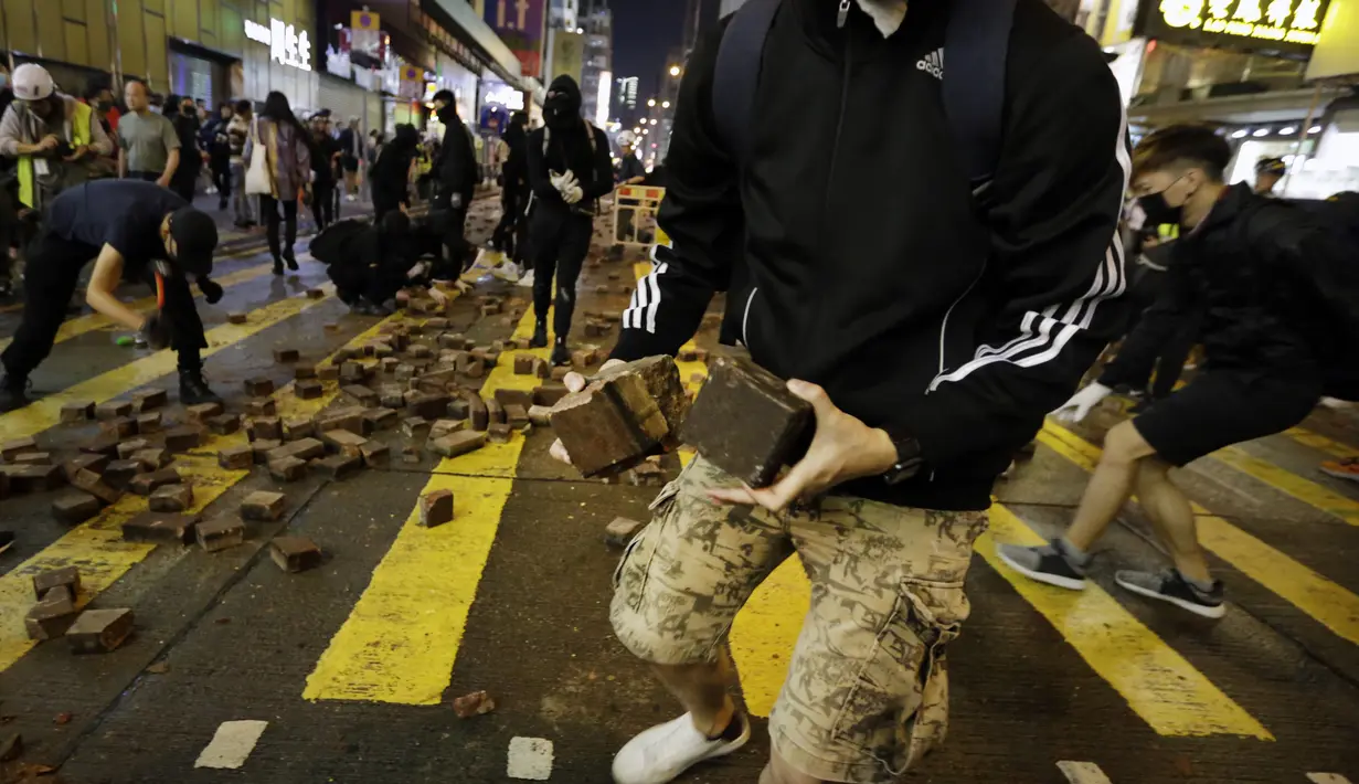Pengunjuk rasa menggunakan mengumpulkan batu untuk mempersenjatai diri selama bentrokan dengan polisi di Mong Kok, Hong Kong (10/11/2019). Ketapel hingga panahan digunakan para demonstran Hong Kong sebagai senjata saat unjuk rasa yang telah berlangsung selama lima bulan. (AP Photo/Dita Alangkara)