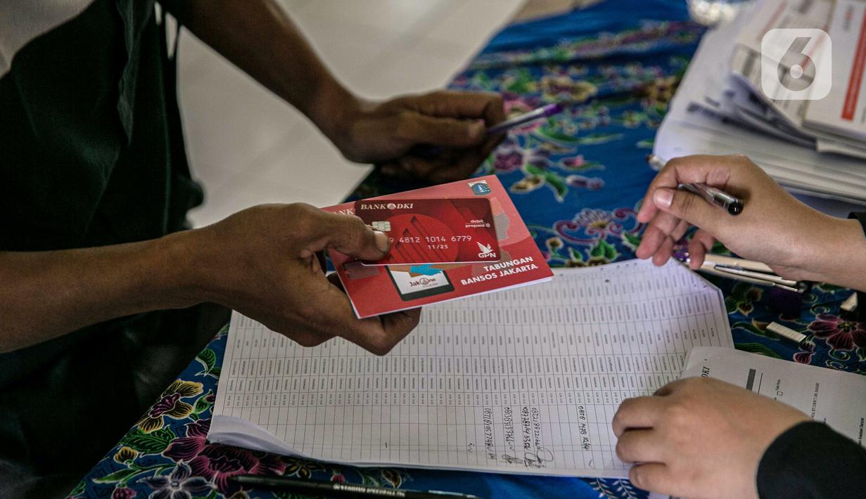 Warga menerima buku tabungan dan ATM saat mengambil Bantuan Sosial Tunai (BST) di SMAN 111, Jakarta, Selasa (19/1/2021). Pemprov DKI Jakarta menyalurkan BST sebesar Rp 300 ribu kepada 1.055.216 KK mulai Januari hingga April 2021. (Liputan6.com/Faizal Fanani)