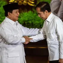 Presiden Republik Indonesia Prabowo Subianto (kiri), yang juga Ketua Umum Partai Gerakan Indonesia Raya (Gerindra), dan Presiden Republik Indonesia ke-7 Joko Widodo saling menyapa di atas panggung pada puncak perayaan ulang tahun ke-17 Partai Gerindra di Sentul International Convention Center (SICC), Bogor, Jawa Barat, Sabtu (15/2/2025). (ADITYA AJI/AFP)