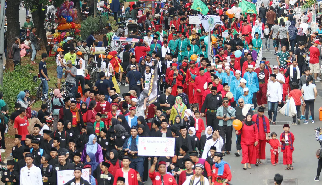 Ratusan warga saat melakukan karnaval di jalan Pintu 1 Senayan, Jakarta, Minggu (24/9). Karnaval tersebut dilakukan dalam rangka HUT Gelora Bungkarno yang ke-55. (Liputan6.com/Angga Yuniar)
