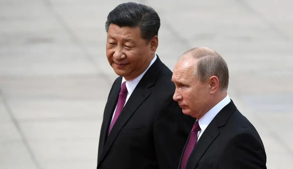 Presiden Rusia Vladimir Putin didampingi Presiden China Xi Jinping saat melakukan kunjungannya di Aula Besar Rakyat, China (8/6). Presiden Xi menyebut hubungan China dan Rusia mampu menghadapi tantangan ekonomi dan diplomatik dari AS.(AP/Pool/ Greg Baker)