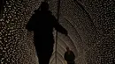 Orang-orang berjalan melalui terowongan lampu bagian dari instalasi cahaya yang dipamerkan menyambut Natal di Royal Botanic Gardens, Kew, London, Selasa (15/11/2022). Selain memamerkan jalur cahaya dengan satu juta lampu di jalur sepanjang 2,7 km, terdapat cahaya imersif, pohon lampu, terowongan cahaya, dan pertunjukkan cahaya air yang mengesankan. (AP Photo/Kirsty Wigglesworth)