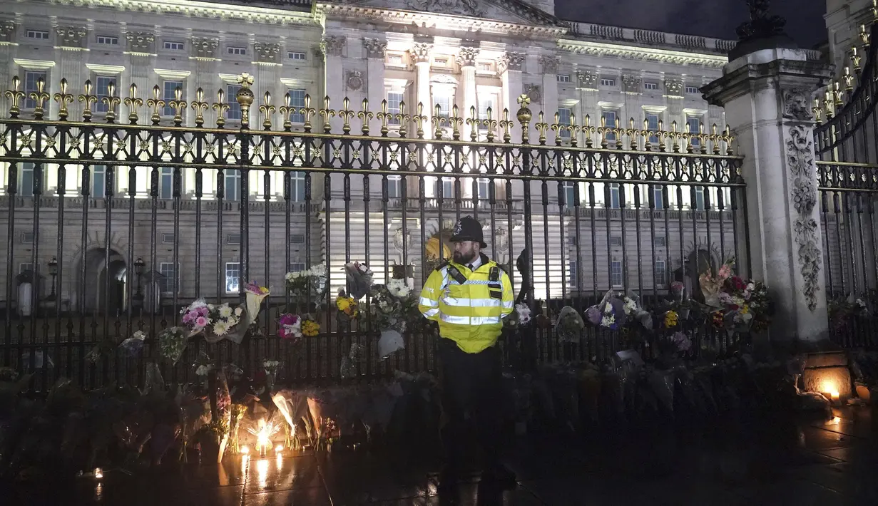 Karangan bunga ditinggalkan di luar Istana Buckingham di pusat kota London, menyusul pengumuman meninggalnya Ratu Elizabeth II, Kamis, 8 September 2022. (Yui Mok/PA via AP)