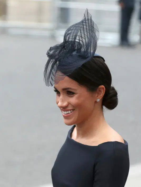 Duchess of Sussex, Meghan Markle tersenyum saat tiba menghadiri kebaktian di Westminster Abbey, London, (10/7). Kebaktian ini digelar untuk memperingati 100 tahun Angkatan Udara Kerajaan Inggris. (Steve Parsons/PA via AP)