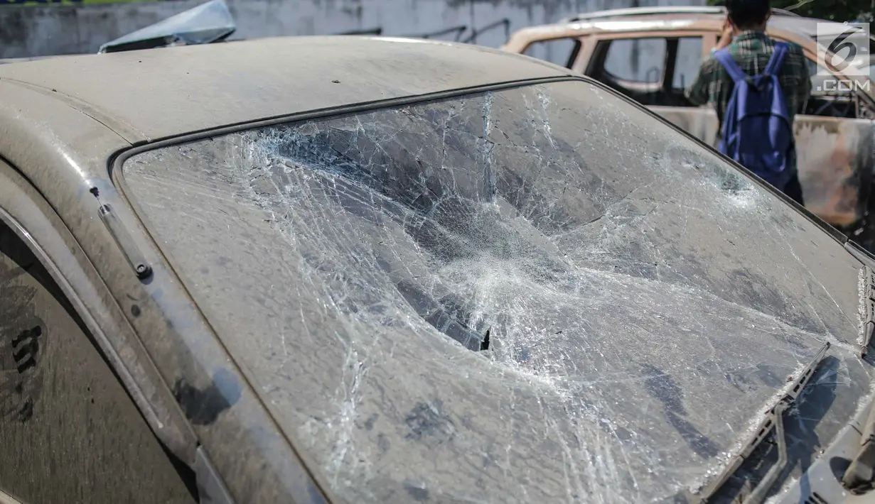 Kondisi mobil yang dibakar dan dirusak massa pasca bentrok pengunjuk rasa dan polisi di Polsek Tanah Abang, Jakarta, Selasa (1/10/2019). Mobil yang sedang terparkir tersebut diduga telah dibakar oleh para demonstran sekitar pukul 22.00 WIB. (Liputan6.com/Faizal Fanani)