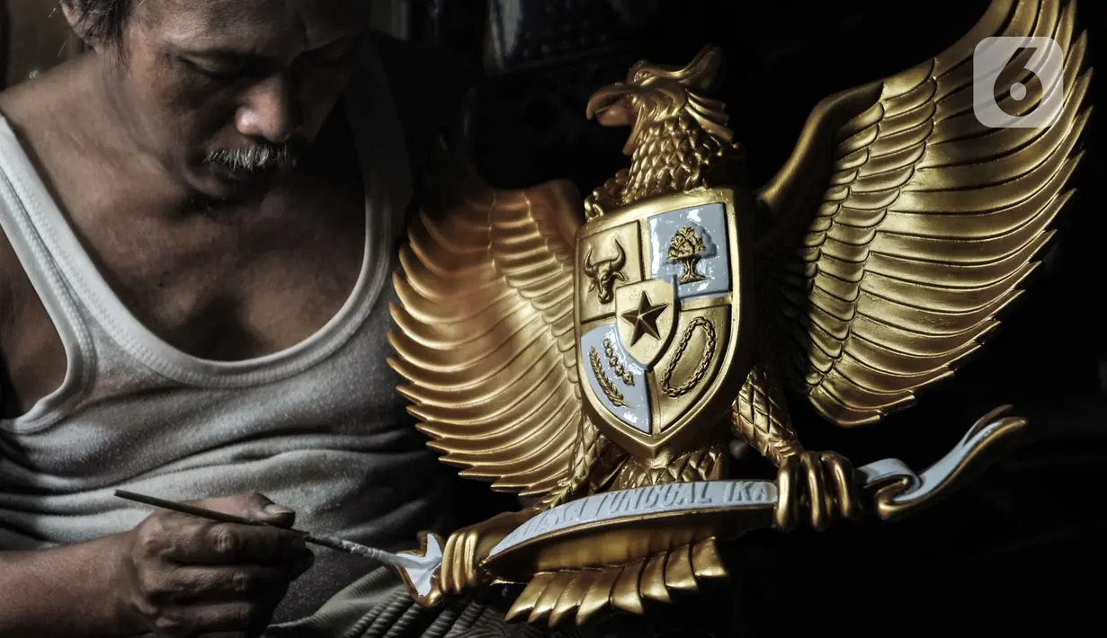 Perajin menyelesaikan proses pewarnaan patung Garuda Pancasila di Jalan Bali Raya, Jakarta, Kamis (1/10/2020). Dampak Covid-19 menyebabkan produksi patung lambang negara Republik Indonesia tersebut menurun dan sempat tutup selama 3 bulan pada masa awal pandemi. (merdeka.com/Iqbal S. Nugroho)