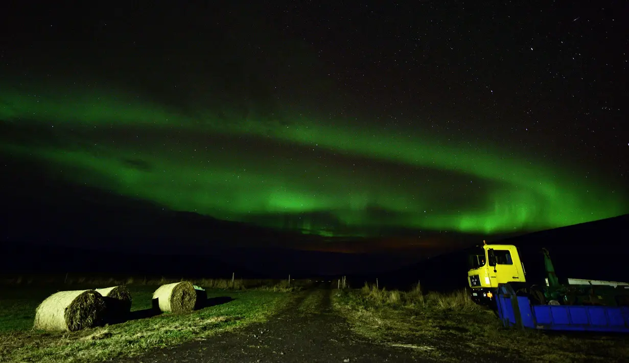 Aurora borealis, juga dikenal sebagai Cahaya Utara terlihat di atas lahan pertanian dekat air terjun Godafoss di Thingeyjarsveit, Islandia, 14 Oktober 2018. Seperti halnya pelangi, Aurora Borealis memiliki gradasi warna yang beragam . (Mariana SUAREZ/AFP)