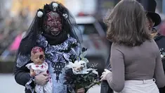 Orang-orang yang mengenakan kostum menakutkan tiba di pusat kota untuk Zombie Walk dan Parade Halloween tahunan di Essen, Jerman, Minggu (31/10/2021). Setiap 31 Oktober sebagian masyarakat dunia ikut memeriahkan perayaan Halloween. (AP Photo/Martin Meissner)