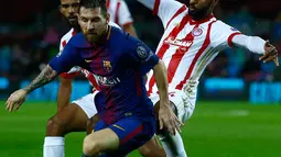 Penyerang Barcelona, Lionel Messi mengendalikan bola dengan kawalan pemain Olympiakos, Omar Elabdellaoui dalam fase grup Liga Champions di Camp Nou Stadium, Kamis (19/10). 10 pemain Barcelona sukses melumat Olympiakos 3-1. (AP/Manu Fernandez)