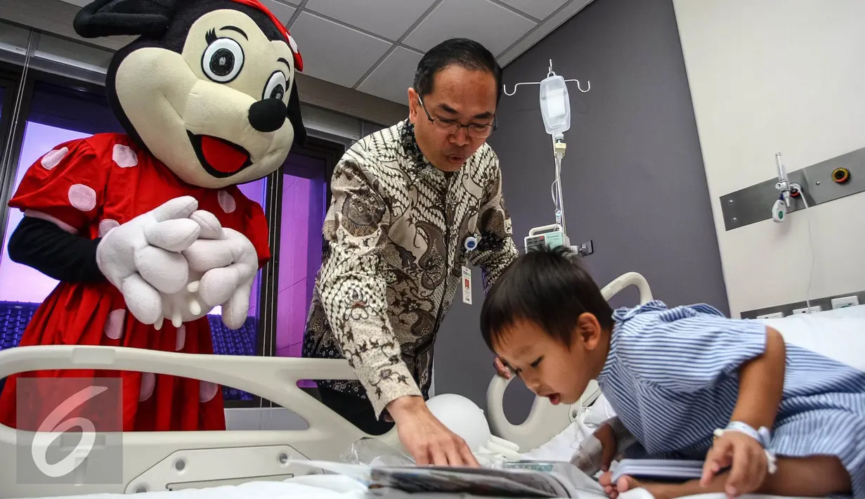 Seorang boneka Minie Mouse bersama Head of Business and Dev. Divison, Alexander Mutak membagikan buku di Rumah Sakit Siloam Karawaci, Tangerang, Sabtu (23/7). Buku dan alat tulis dibagikan dalam rangka Hari Anak Nasional. (Liputan6.com/Fery Pradolo) 