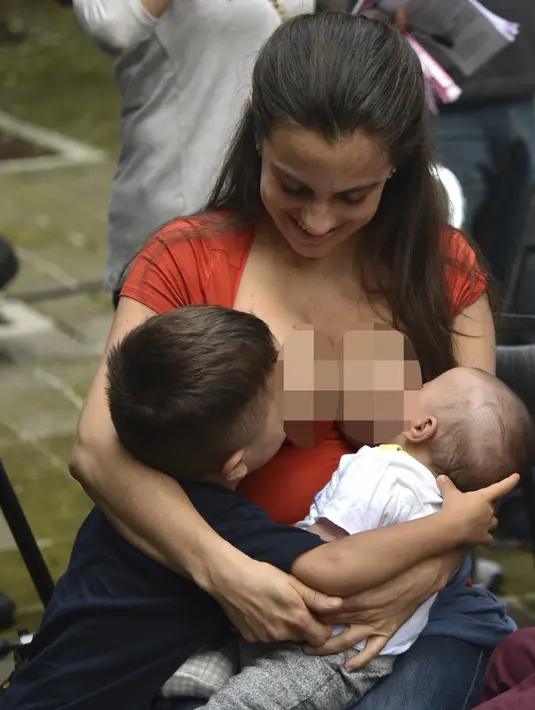 Seorang ibu menyusui anak mereka selama festival menyusui "Big latch On" yang diadakan di Bonatic Garden of the Chapultepec Park di Mexico City, Meksiko (5/8). Festival menyusui ini dipromosikan oleh UNICEF. (AFP Photo/Yuri Cotez)