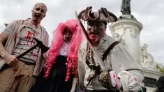 Tiga orang peserta mengenakan kostum zombie berpose saat mengikuti "Zombie Walk" di Paris, Prancis (7/10). Acara ini diadakan setiap tahun dan manjadi daya tarik untuk wisatawan. (AFP Photo/Thomas Samson)